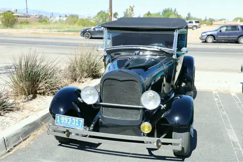 Black Ford Model A with its original grille and headlamps at the car show