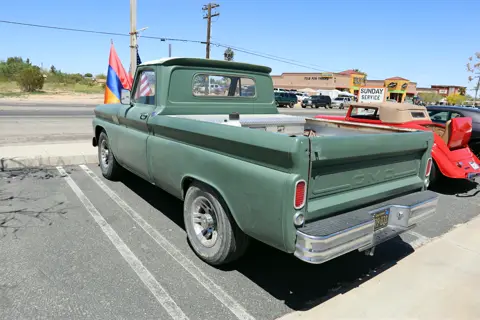 Restored green Chevy pickup with an Armenian flag flying from the bed