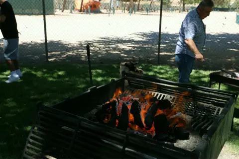 Grilling over open flames at the parish picnic barbecue pit