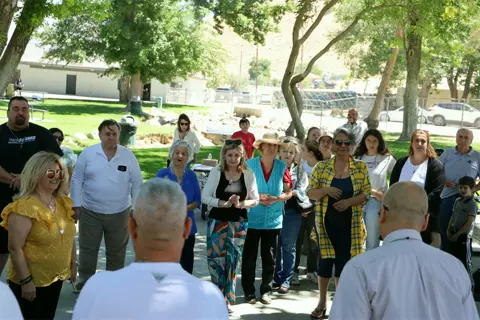 The community gathered in a circle for the blessing before the picnic meal