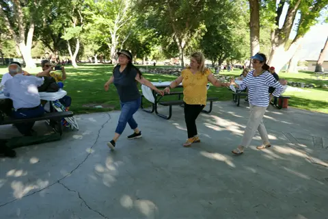 Parishioners dancing a traditional circle dance on the park path